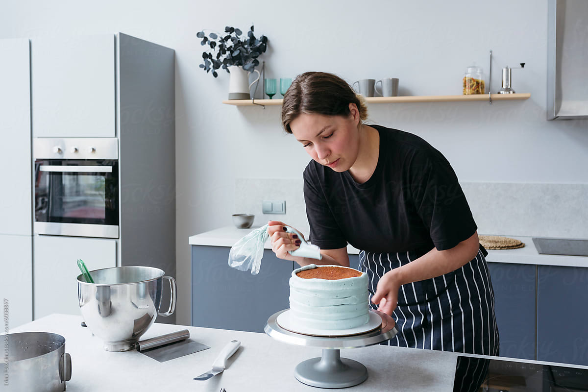Woman Decorating Cake in Kitchen