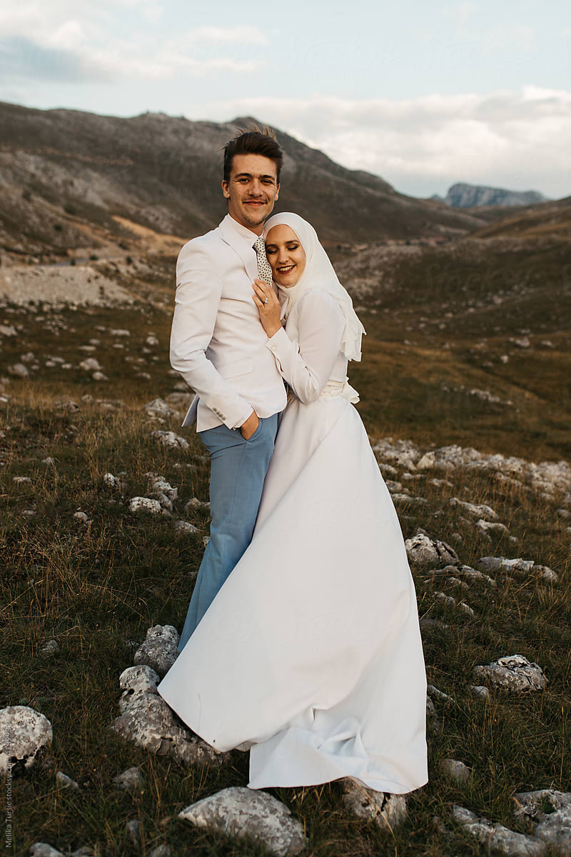 Happy couple standing and hugging in the mountains