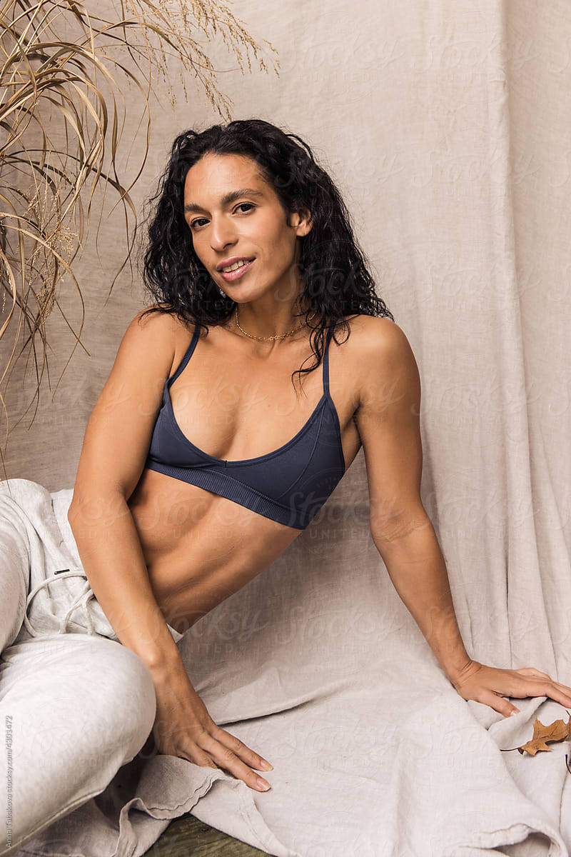 Woman In Cozy Sweatpants And Sport Bra Smiling by Stocksy