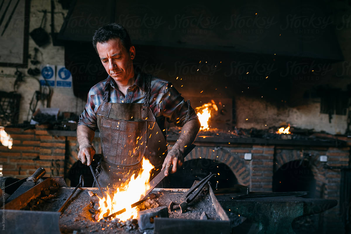 Blacksmith working with fire in workshop