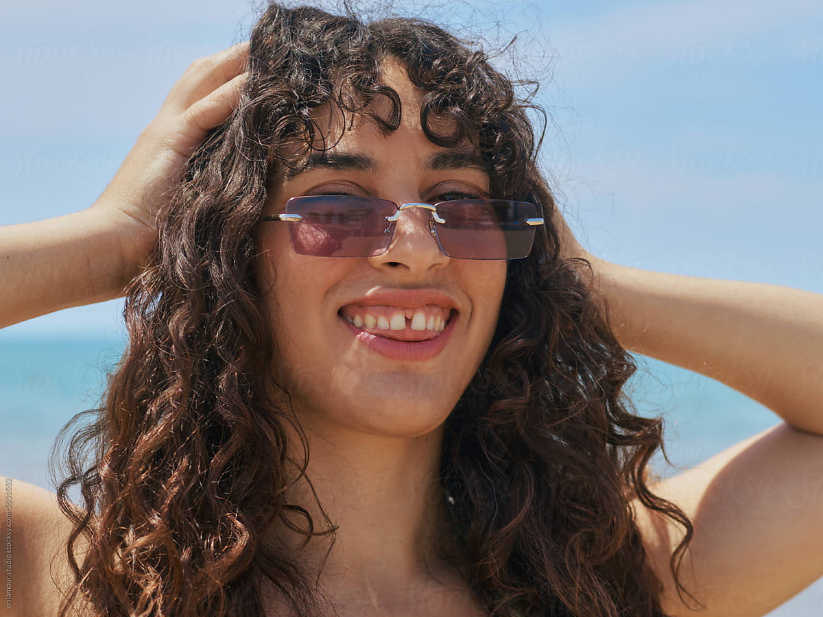 Vintage Vibe: Woman\'s Close-up with Curly Hair and Stylish Shades