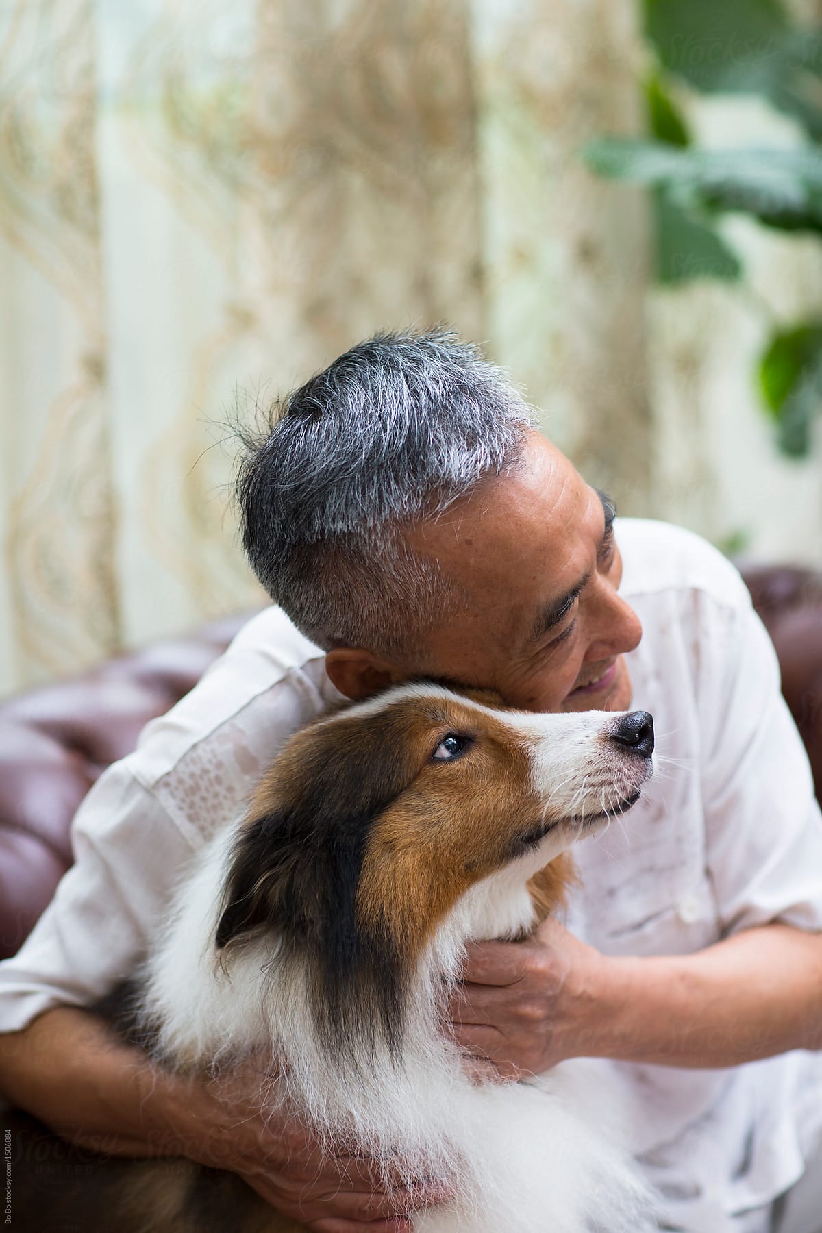 one asian Senior man with his senior dog indoor