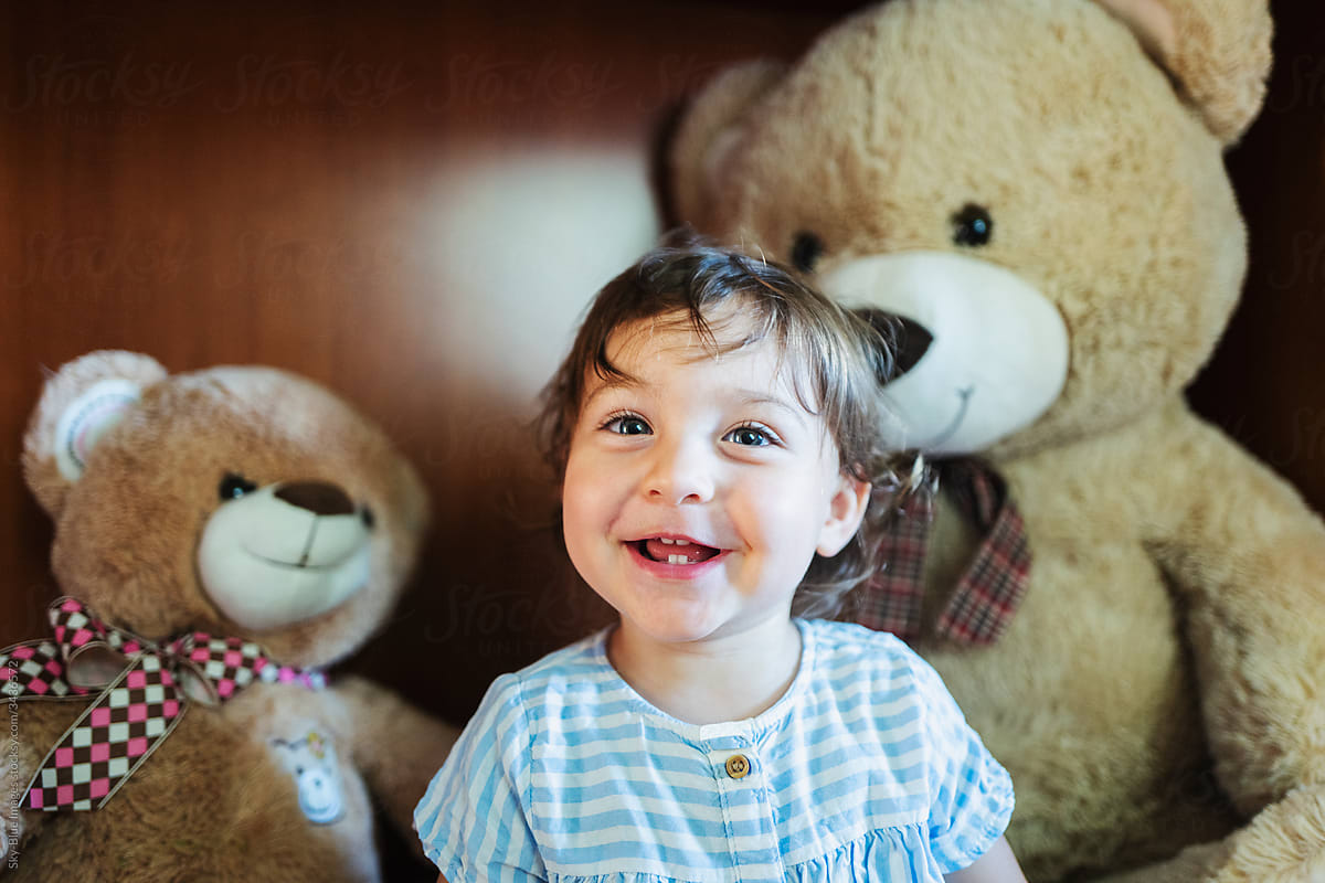Toddler surrounded by teddy bears