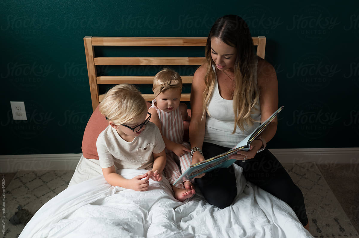 Mom reads book to toddlers