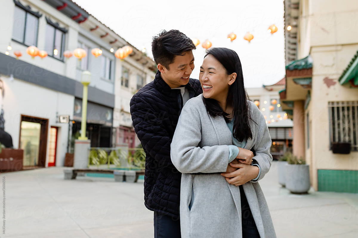 Happy Asian Couple in Laugh While Embracing on a Date