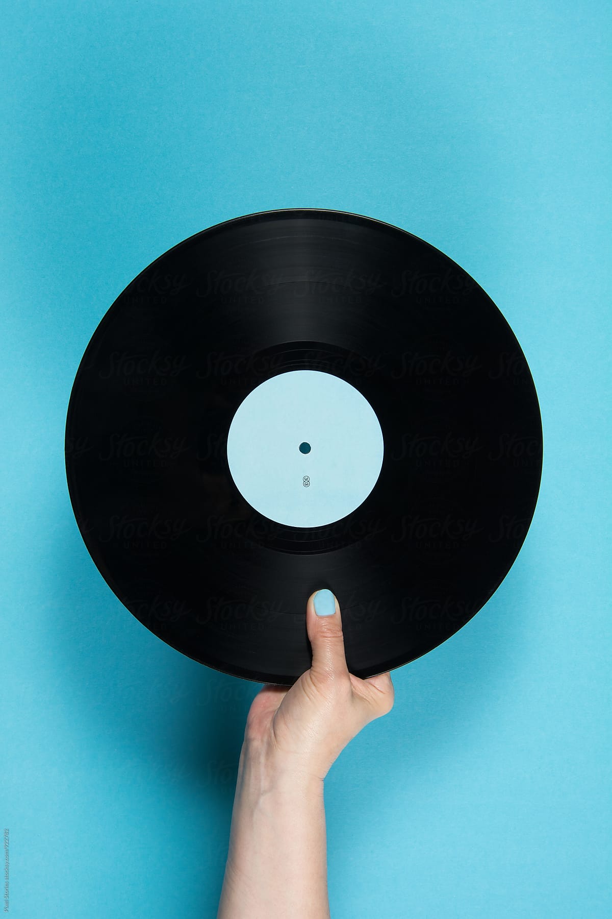 Hand Holding Vinyl Record Over Blue Background by Pixel Stories - Music ...