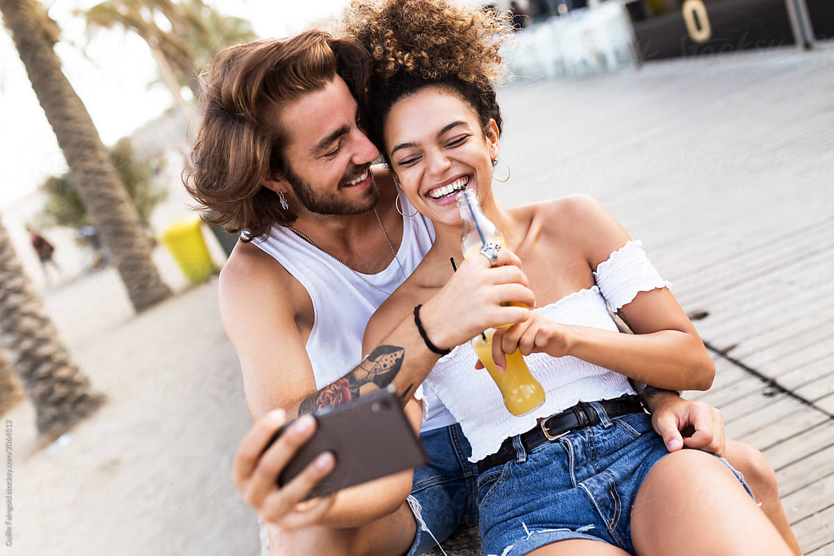 Happy couple taking selfie drinking juice.