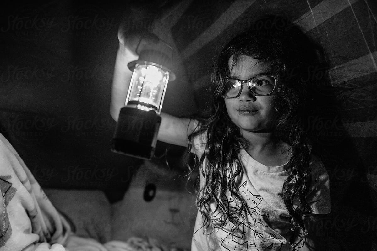 Young girl wearing glasses looking at light.