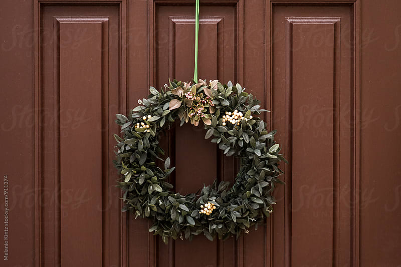 Wreath with white flowers on brown door