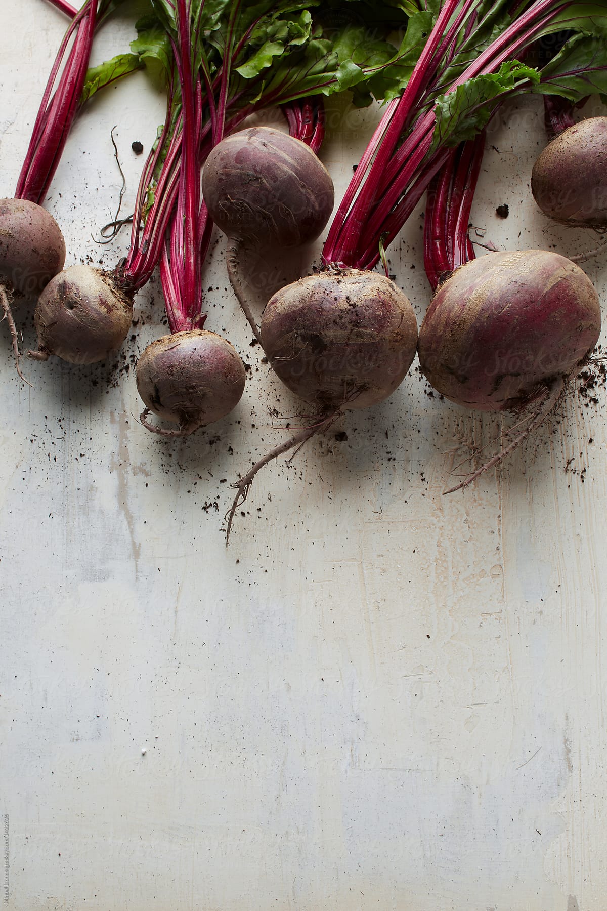 Bunch of fresh and raw red beets on painted board