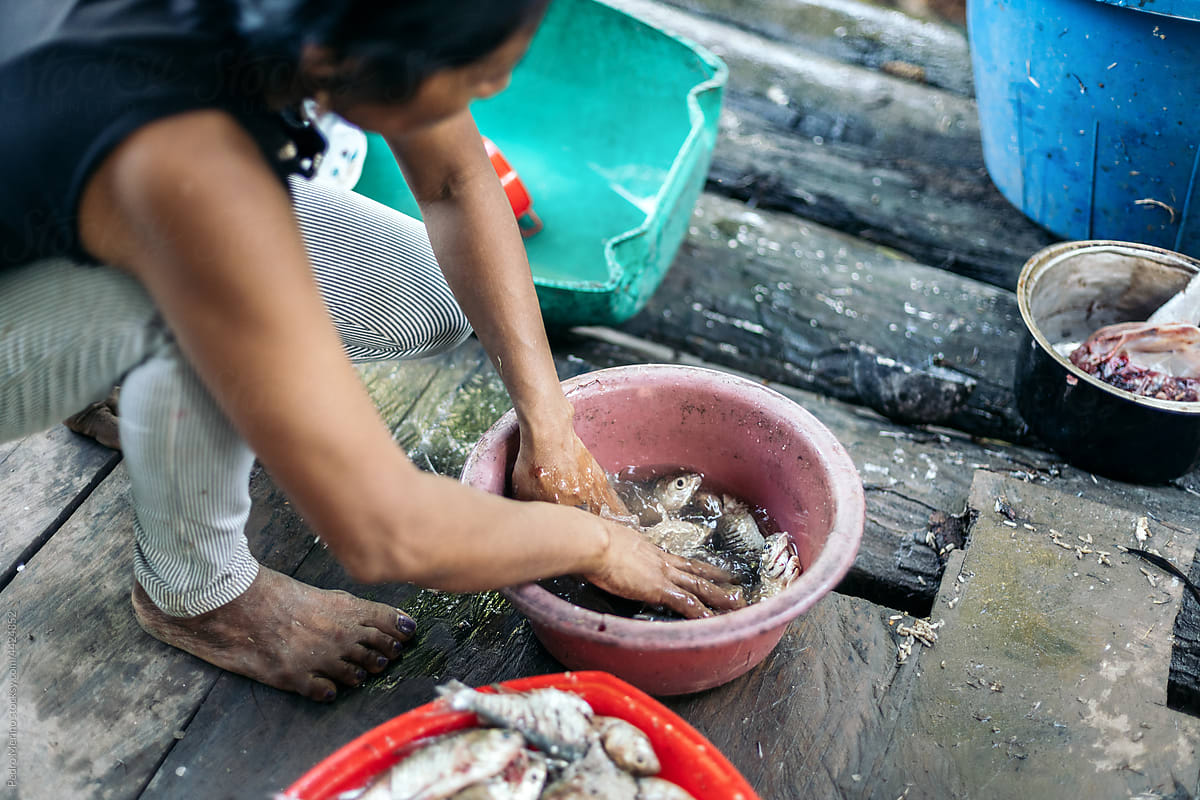 Peruvian woman cleaning fish