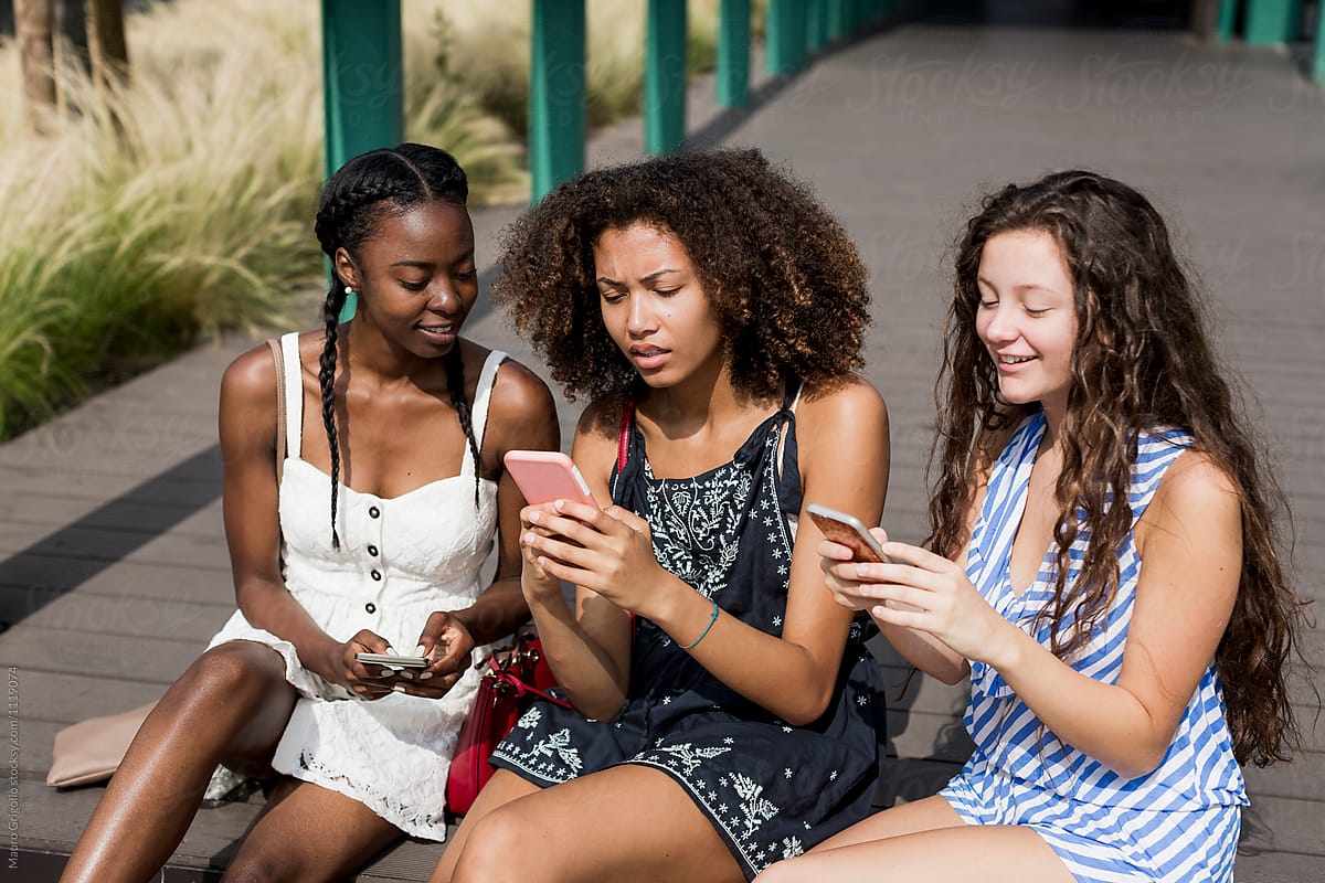 Women Use Their Phones On A Sunny Day Outdoor By Stocksy Contributor Mauro Grigollo Stocksy 