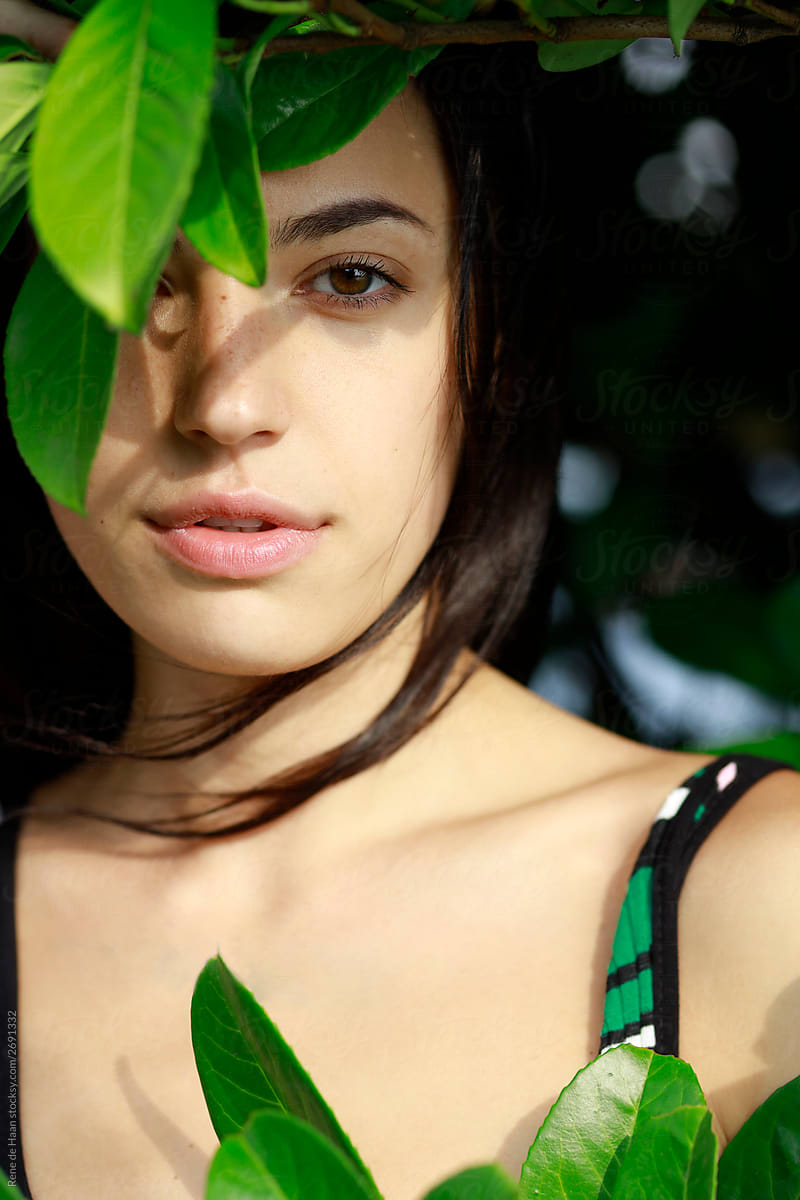 young woman behind leaf