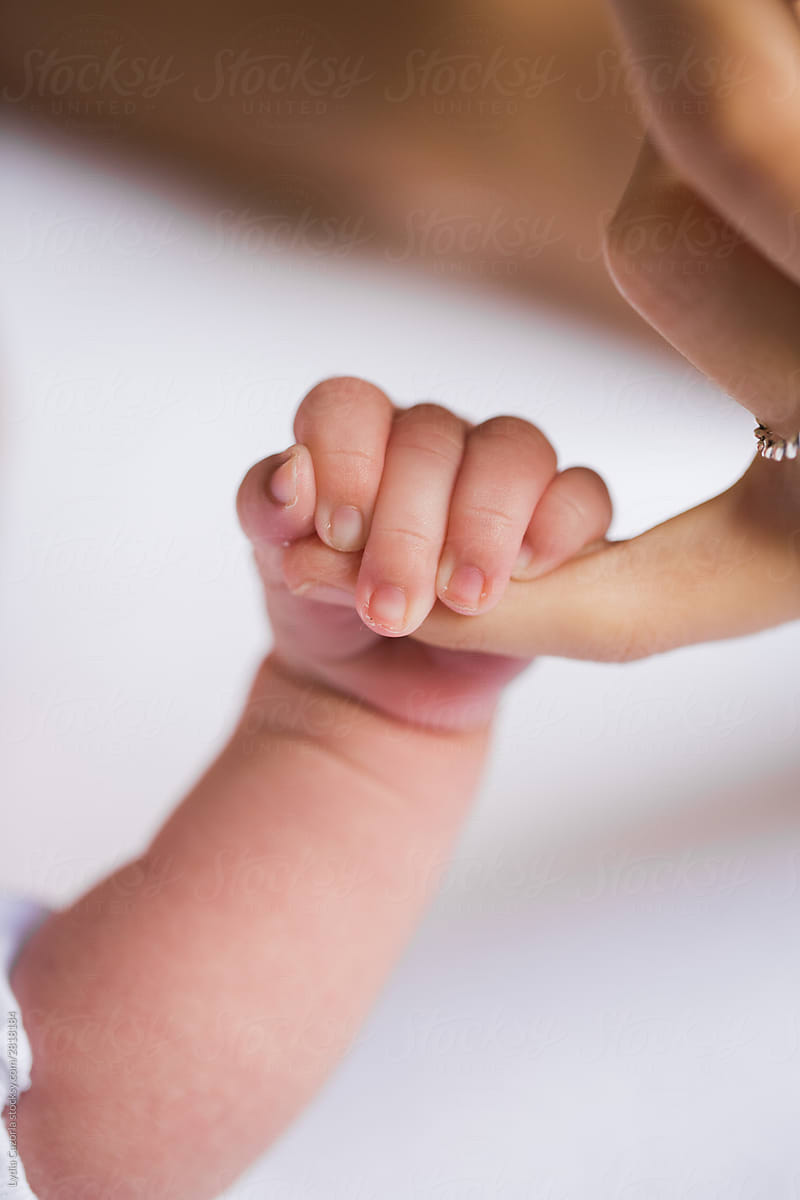 Baby taking her mother's finger