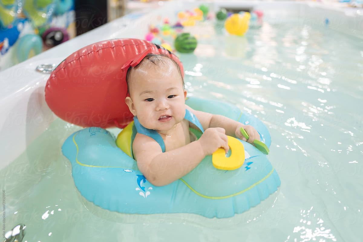 A baby girl swimming in a swimming ring
