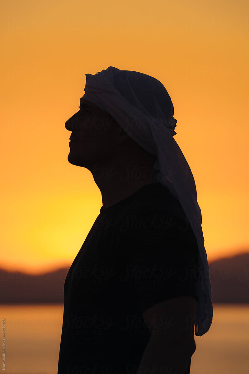 Profile silhouette shot of a man wearing a Kafiyyeh.