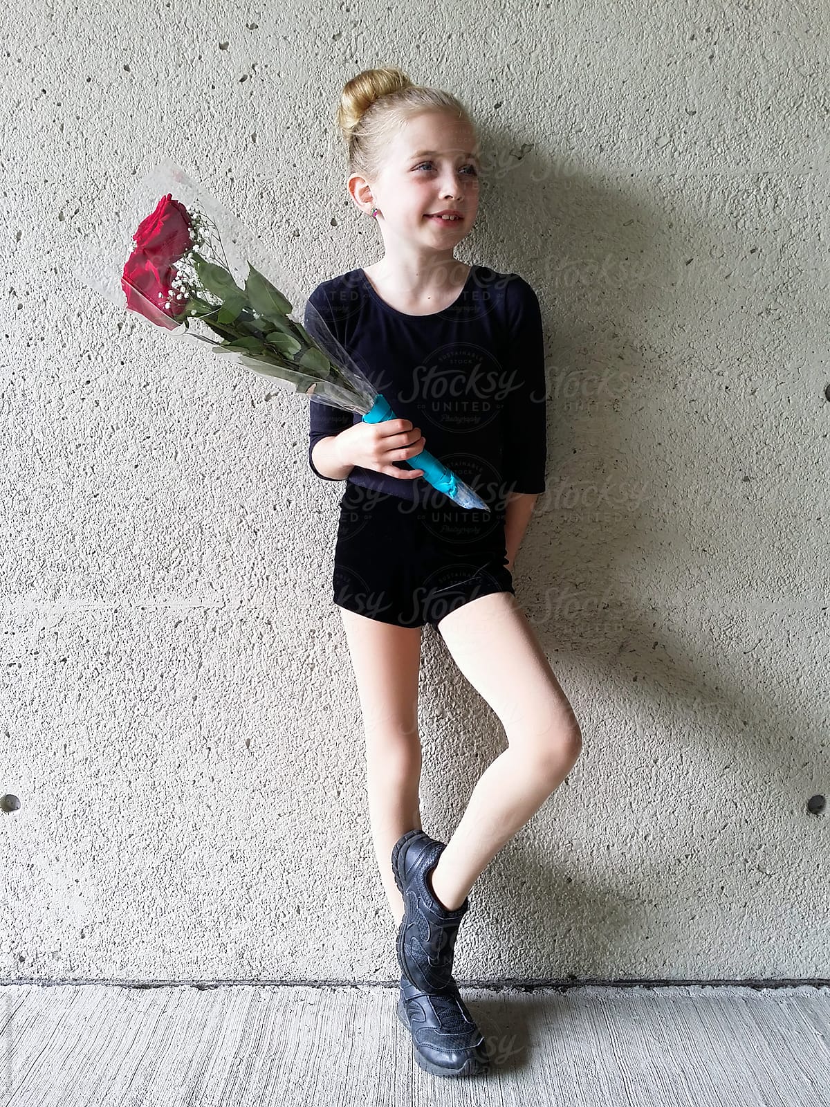 Portrait Of Little Girl Holding A Bouquet Of Red Roses After Dance 