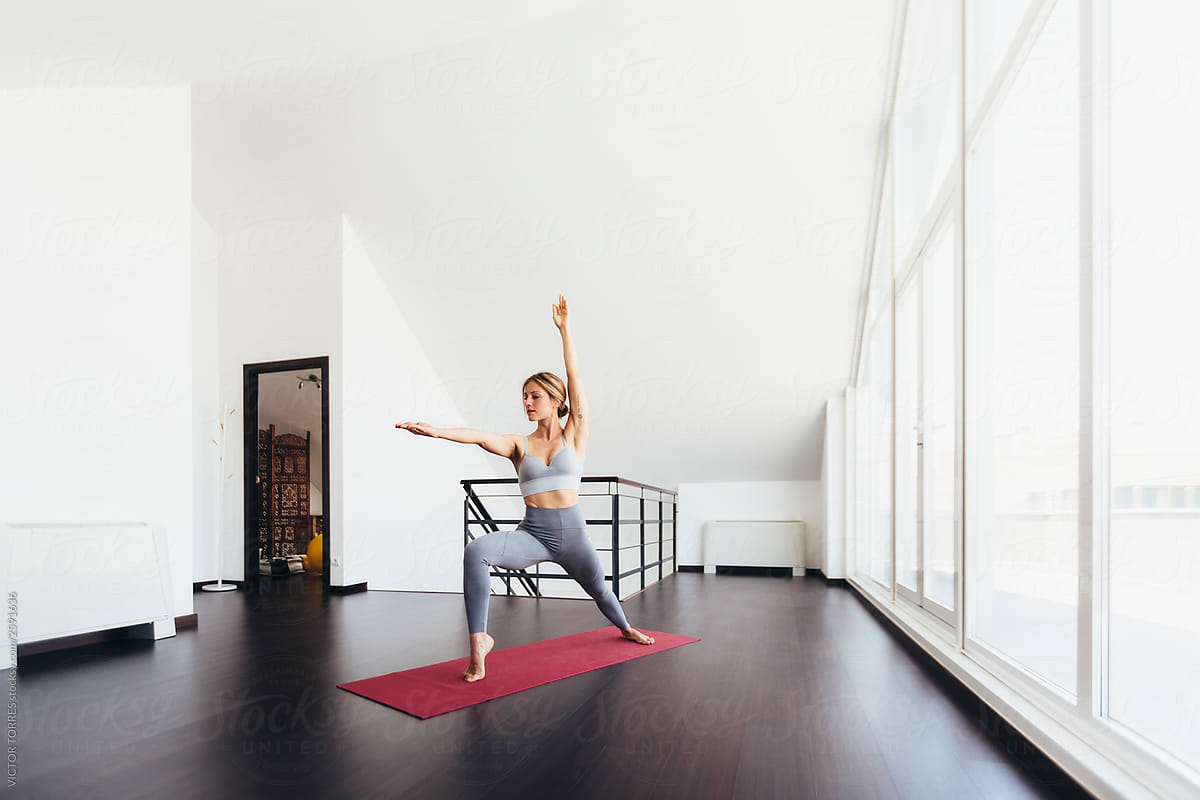Beautiful young woman doing yoga postures in luxury apartment