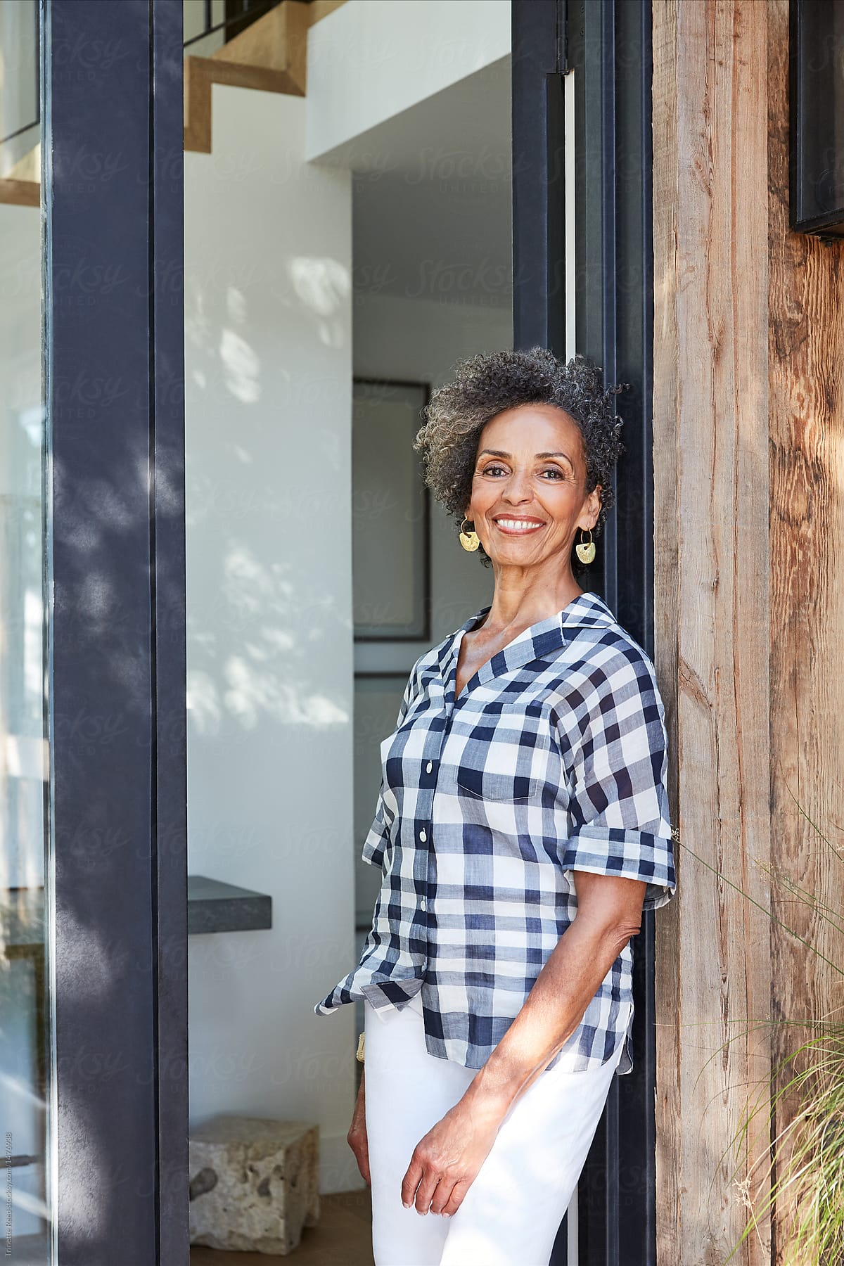 Portrait Of Black Senior Woman Home Owner In Front Doorway Of Home Del Colaborador De Stocksy