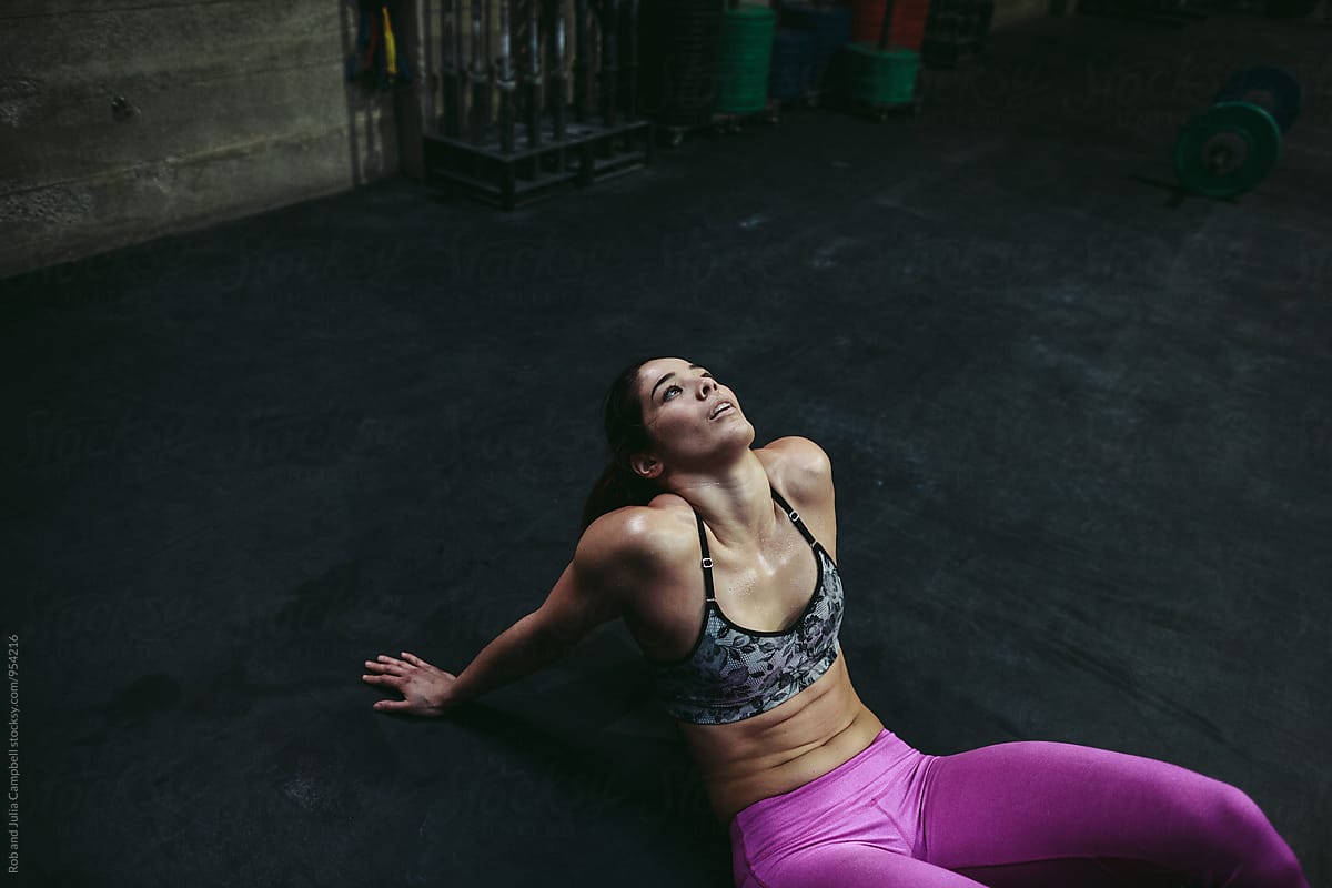 Active, fit mixed race woman exhausted after intense workout at gym