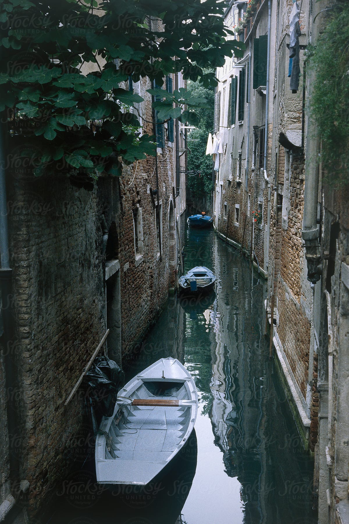 Narrow canal with flat-boats in Venice