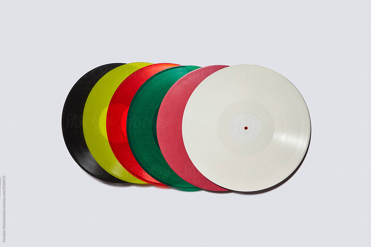 Set of colorful vinyl records on a light gray background.