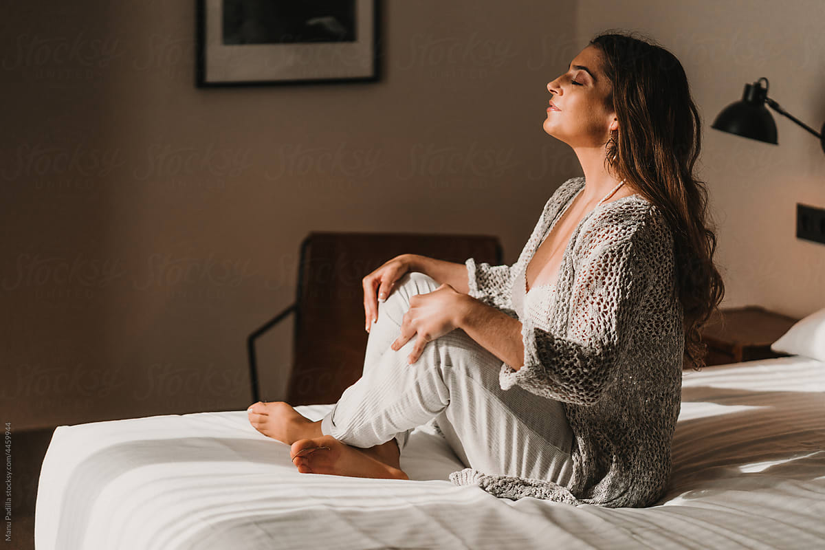 Serene Woman Sitting On Bed And Meditating In Morning Del Colaborador De Stocksy Manu Padilla