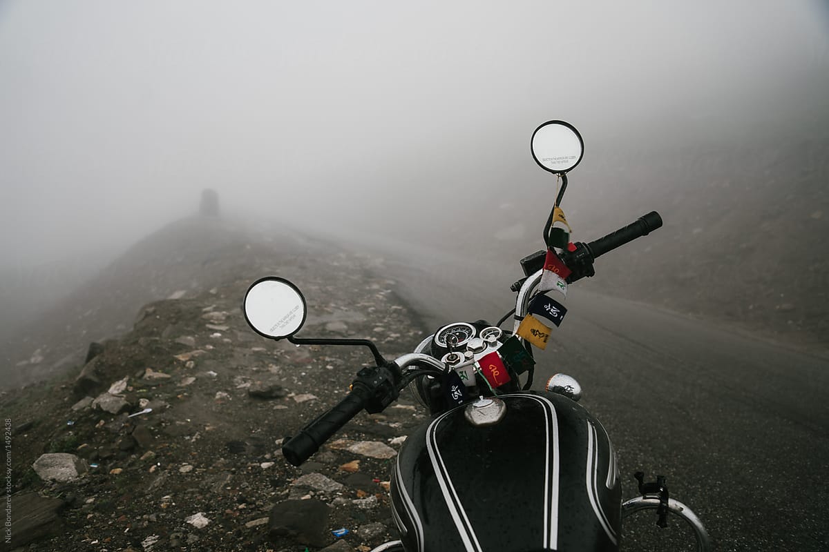 Close-up of Black motorcycle parked on the foggy road