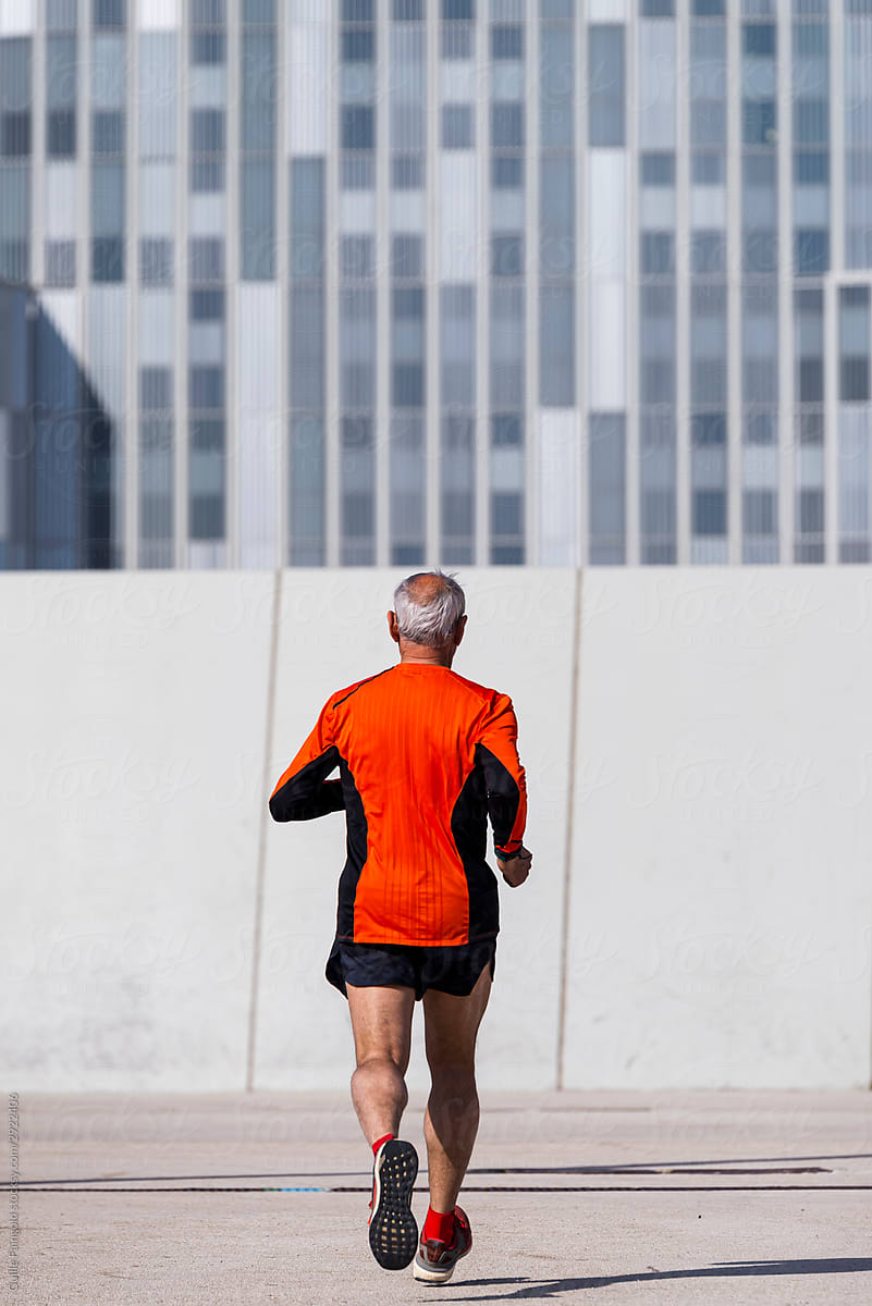 Senior runner in modern city