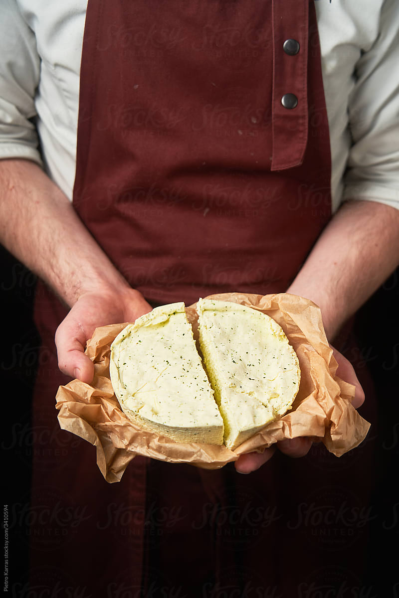 Seller with artisan cheese in hands