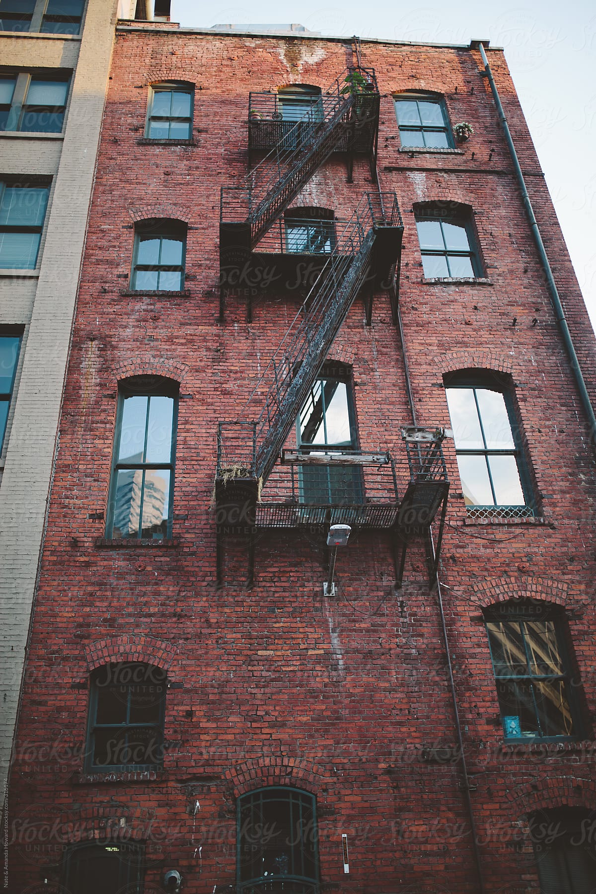 tall brick city building with fire escape.