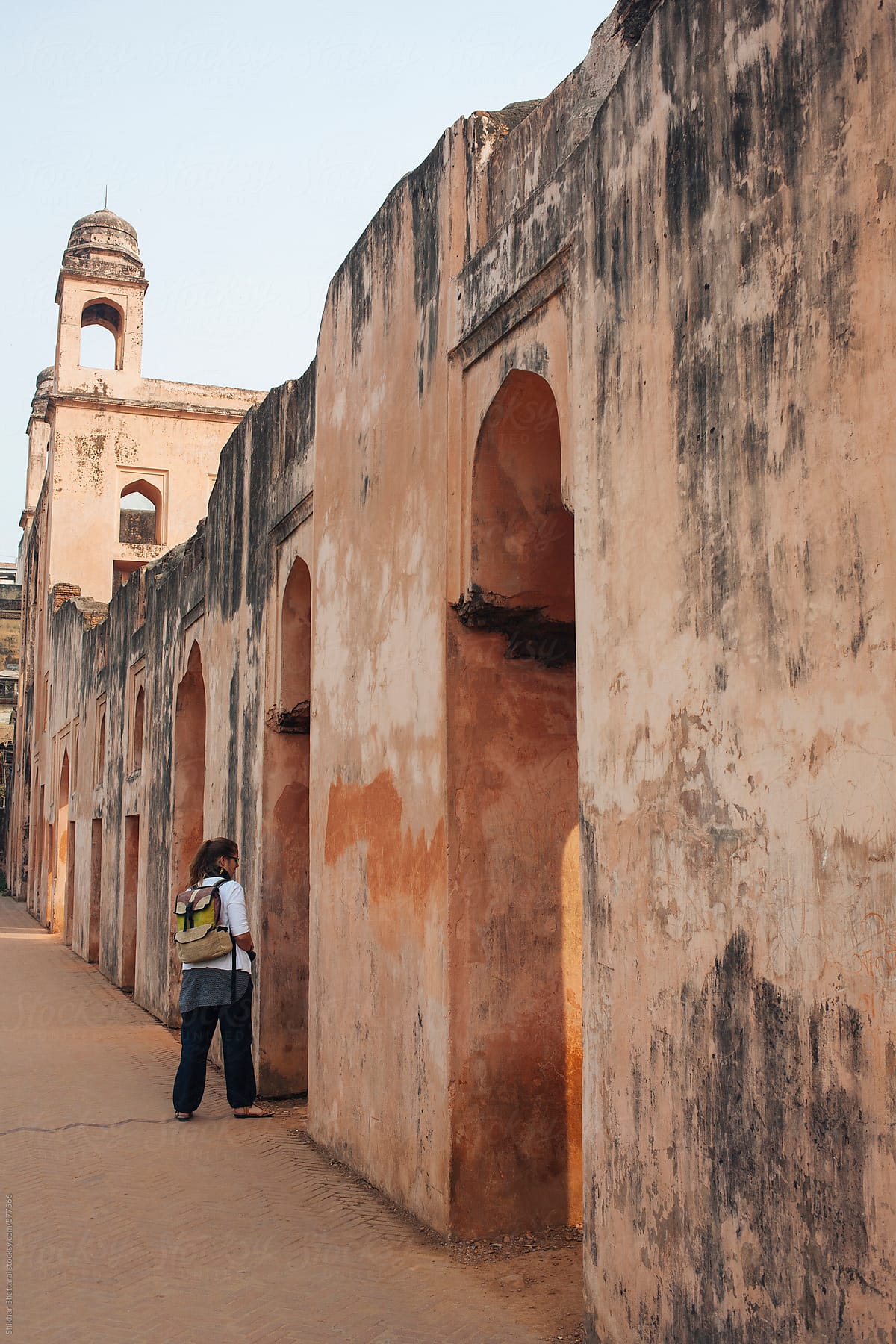 A young traveller walking by an old fort in Asia.