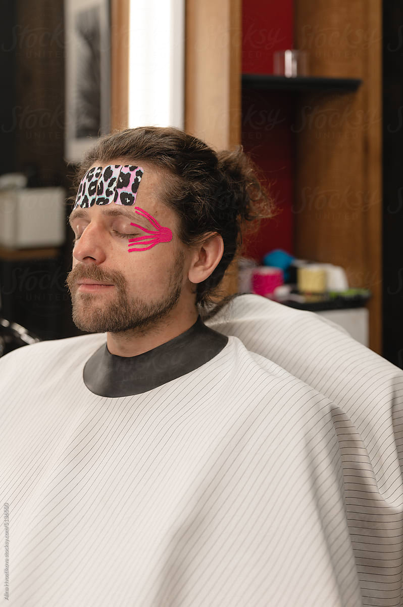 Bearded man with kinesio tapes on face