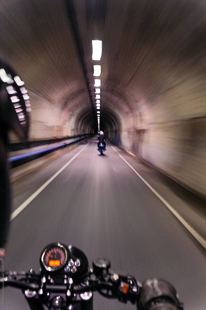 young men ride motorcycles through dark tunnel at very high speeds