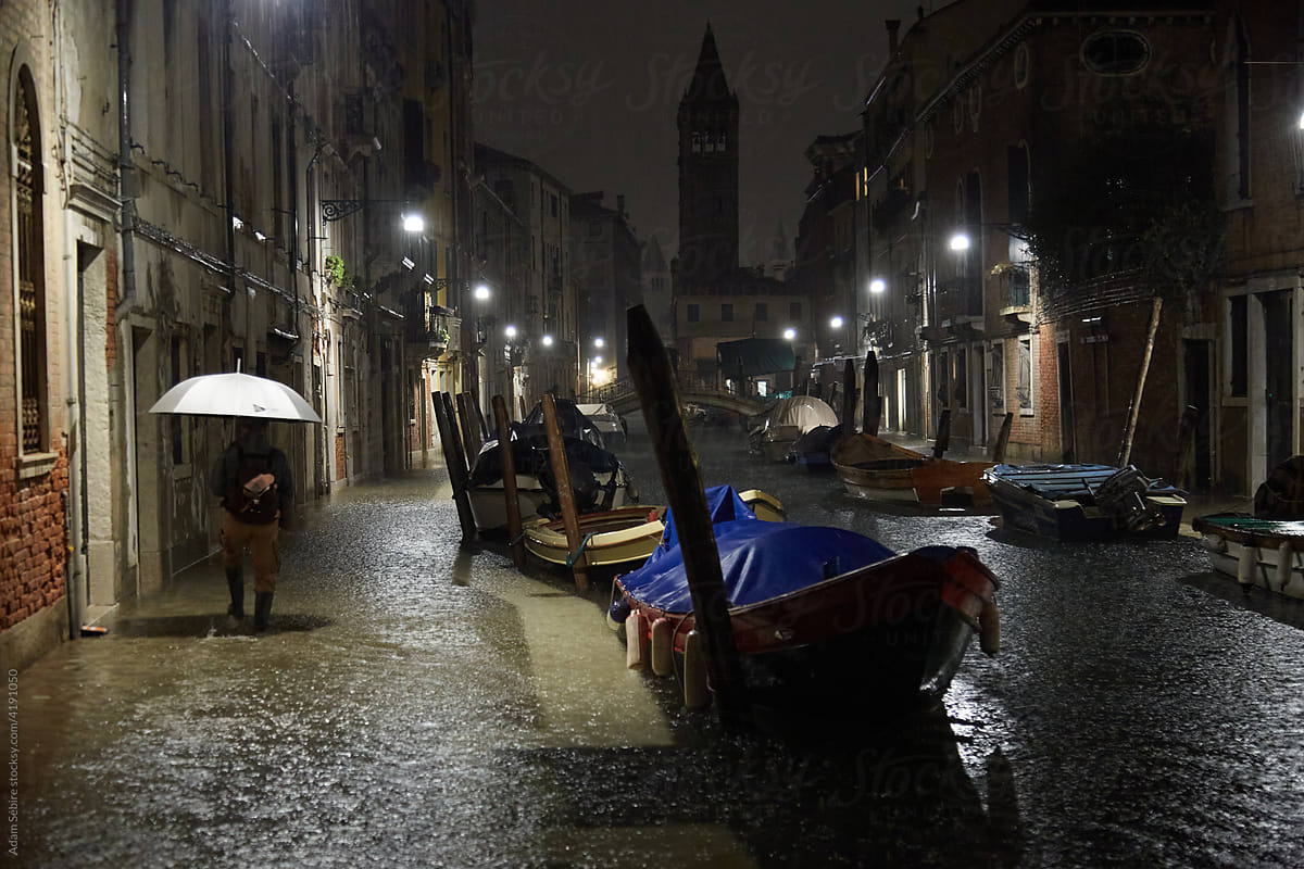 Venetian local with umbrella, flood rains overflow canal