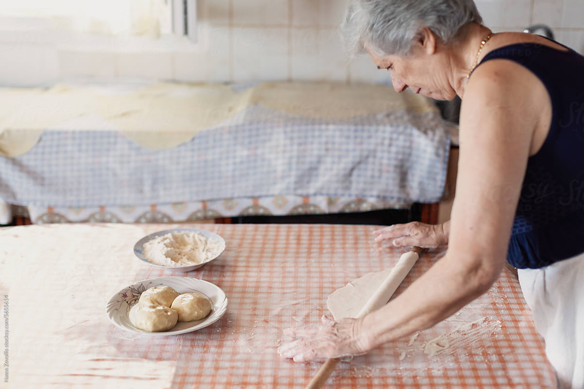Senior woman preparing a greek traditional food in her kitchen