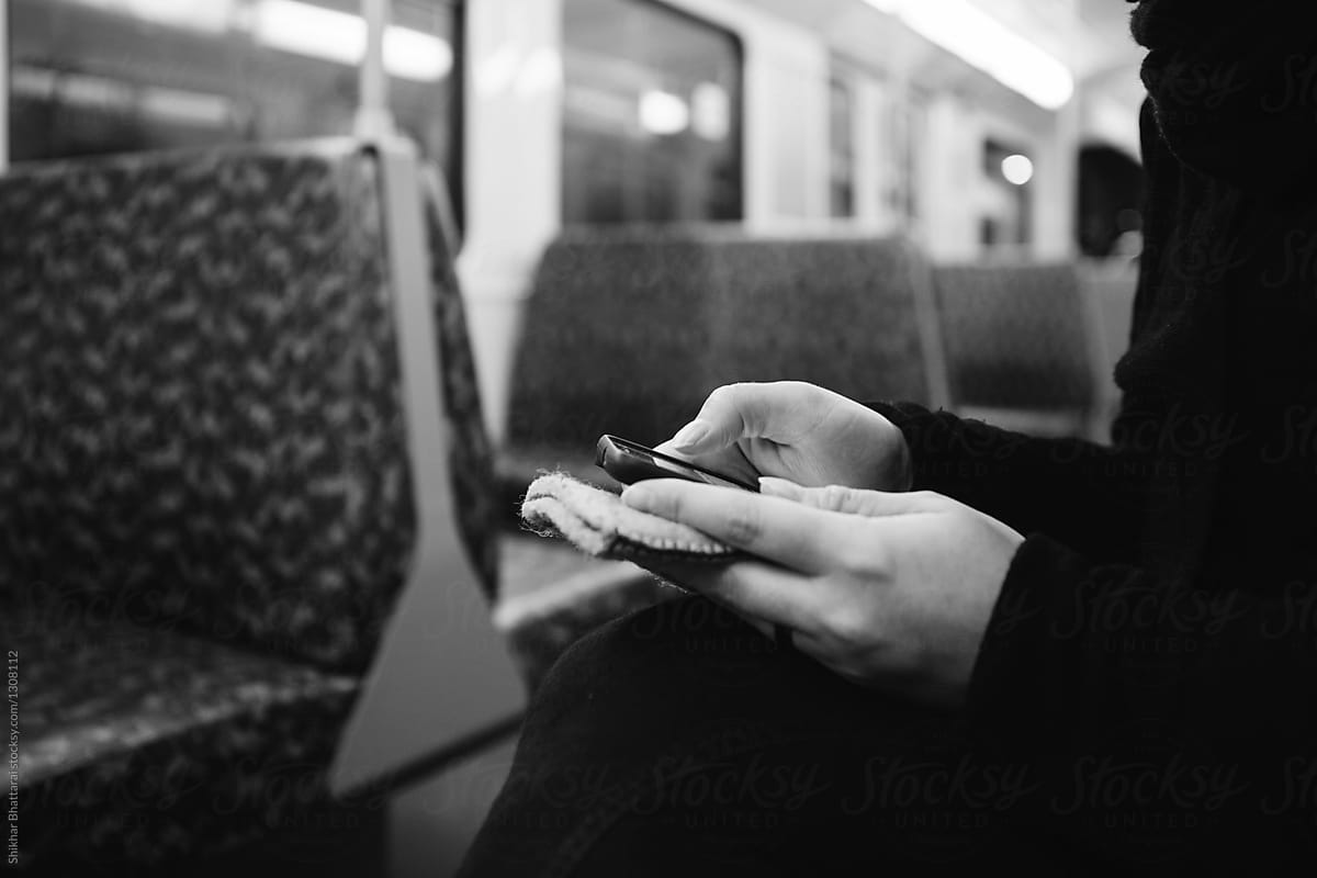 hands of a woman using her cellphone on a tram.