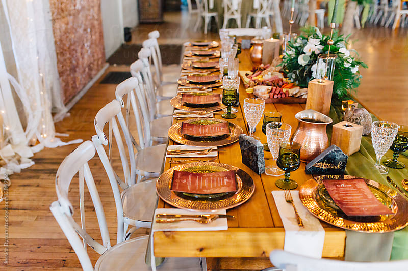 A venue set up for a wedding reception with copper and green colored decor.