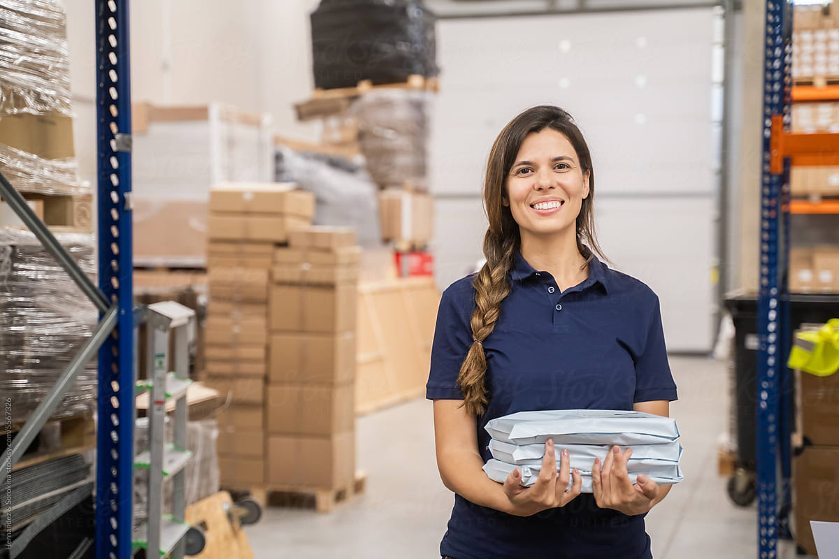Smiling Worker Holding Packages At Warehouse