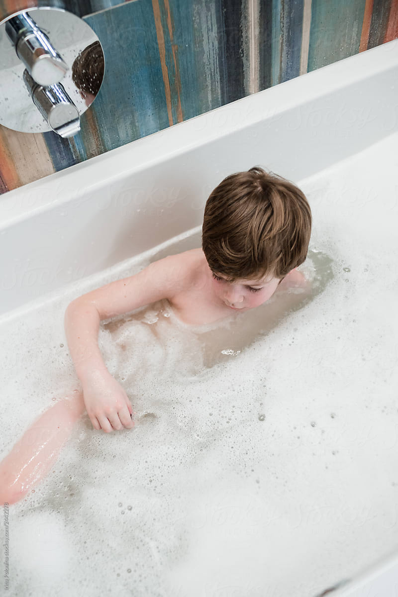 Little caucasian boy washes in the bath