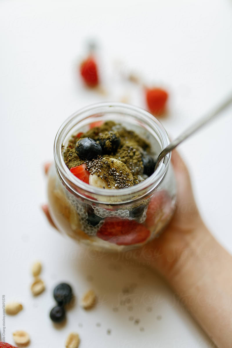 Hand Holding Cup of Chia Seed Pudding Fruit Bowl