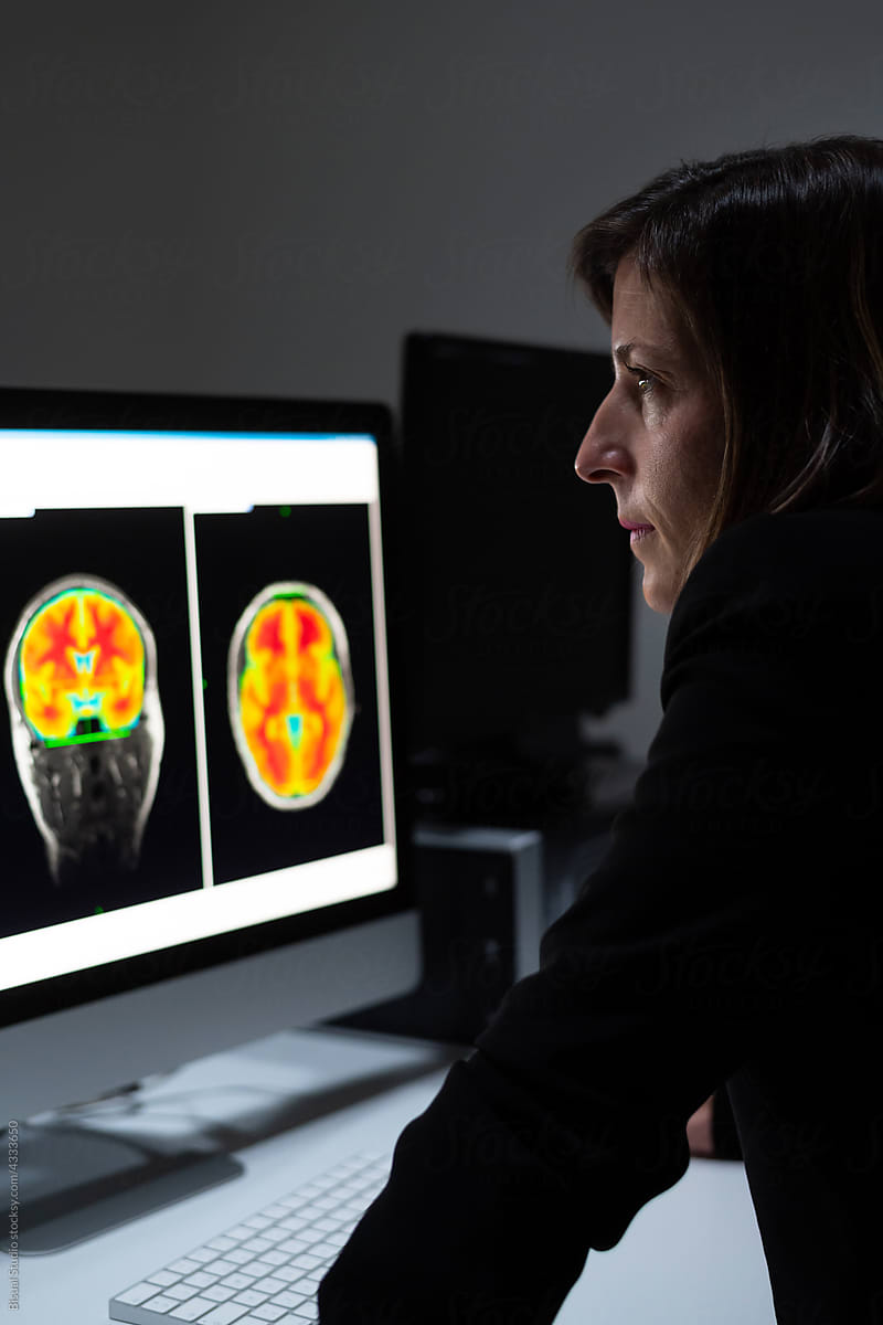 Female analyzing brain scan on computer
