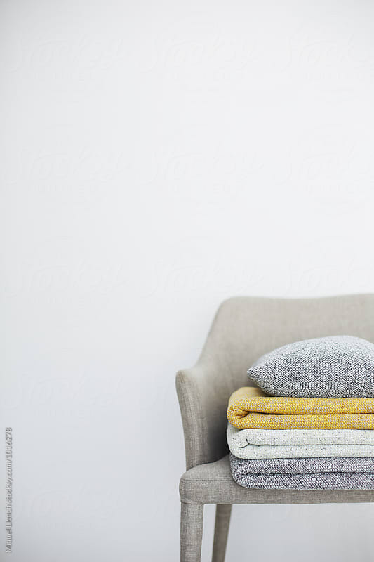 Set of folded blankets and pillow on a chair