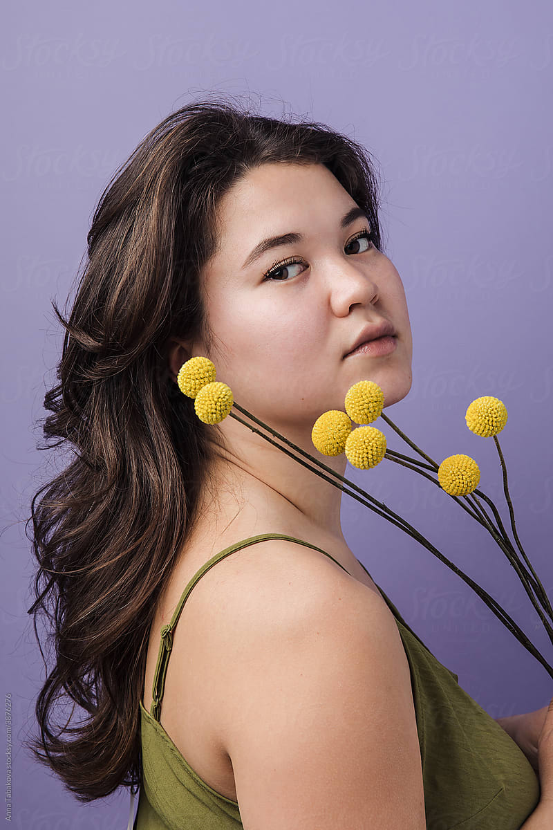 Portrait of a woman with yellow craspedia flowers