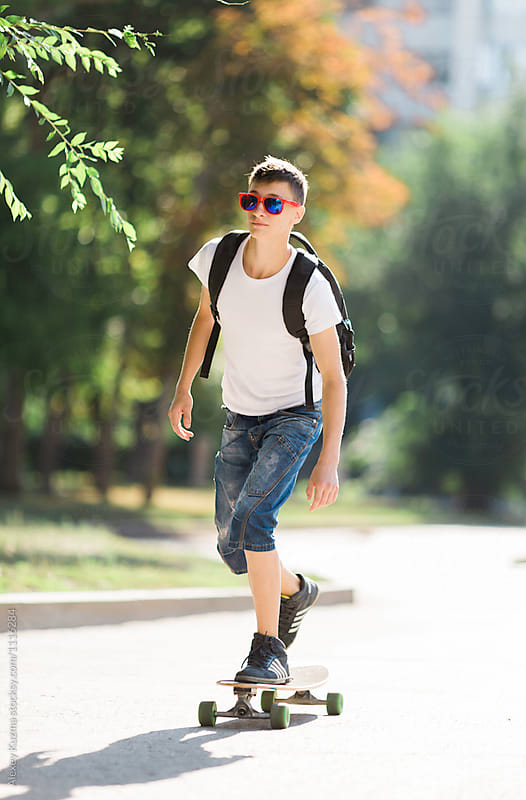 young man riding on longboard on the street