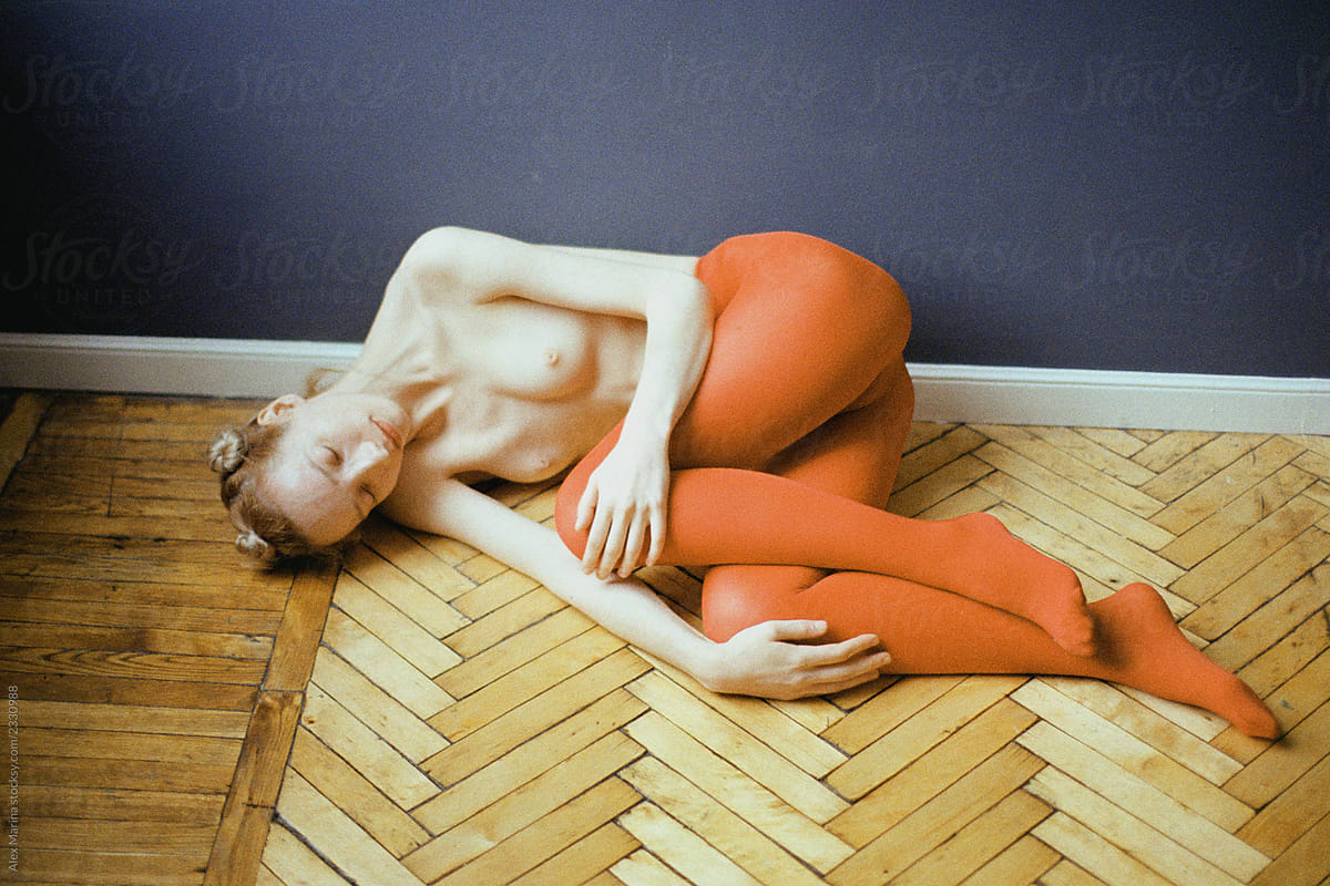 Topless Woman With Red Pantyhose On The Wooden Floor