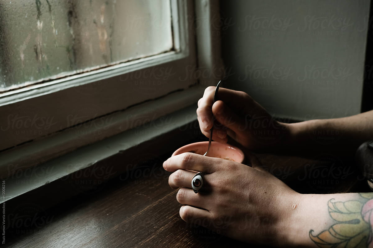 taking a hot coffee in front of a steamed window wearin an eye ring
