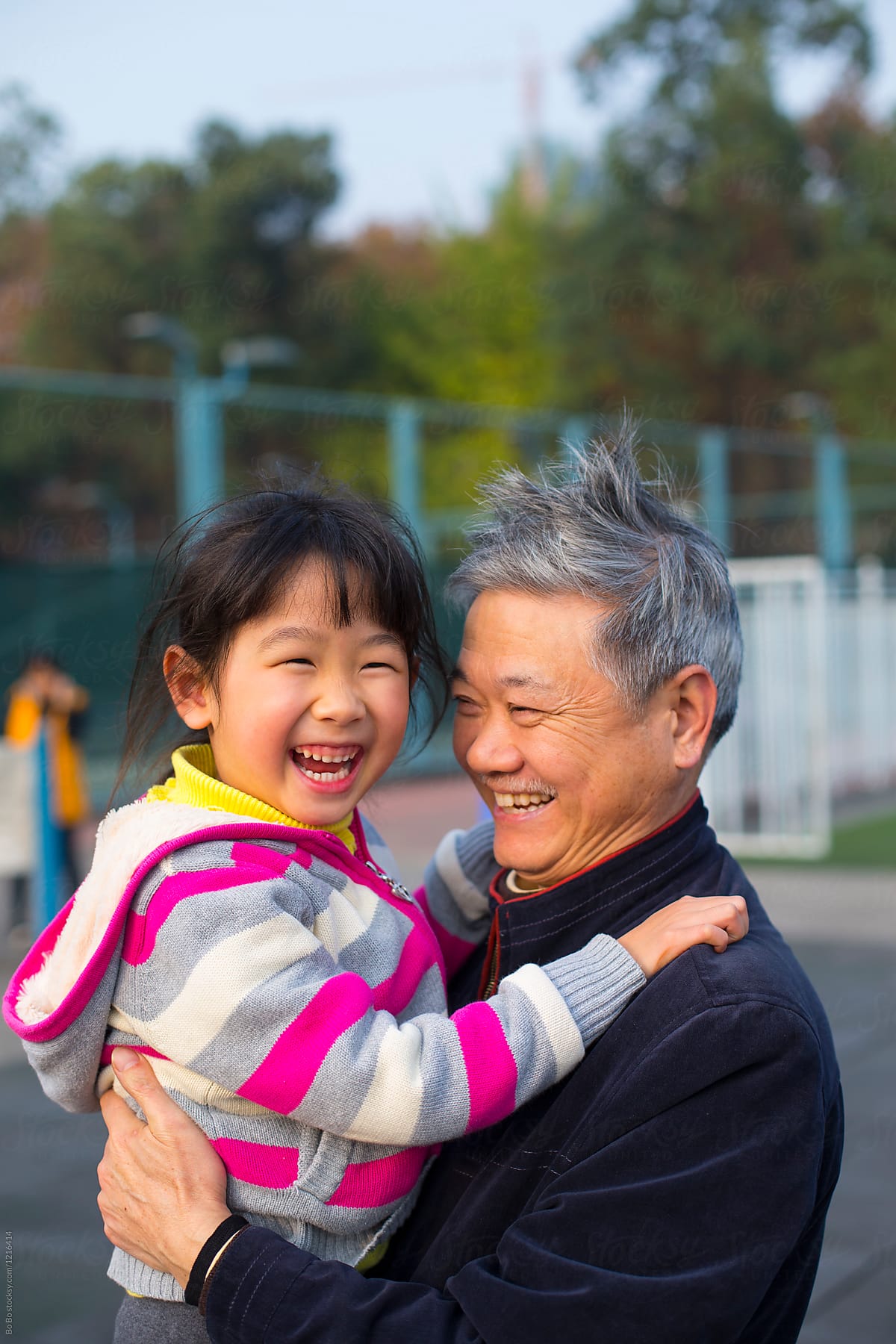 Senior Chinese Man Holding his Granddaughter Smile outdoor