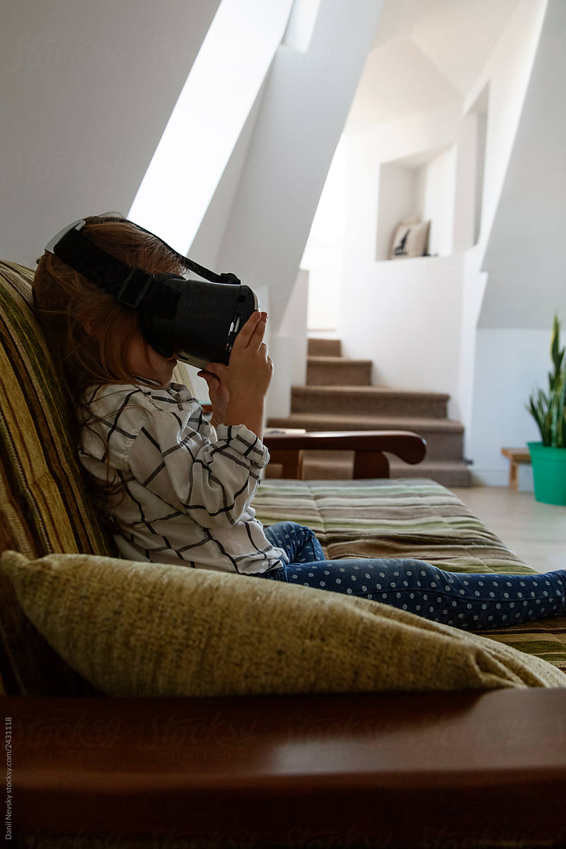 Girl in VR headset sitting on sofa