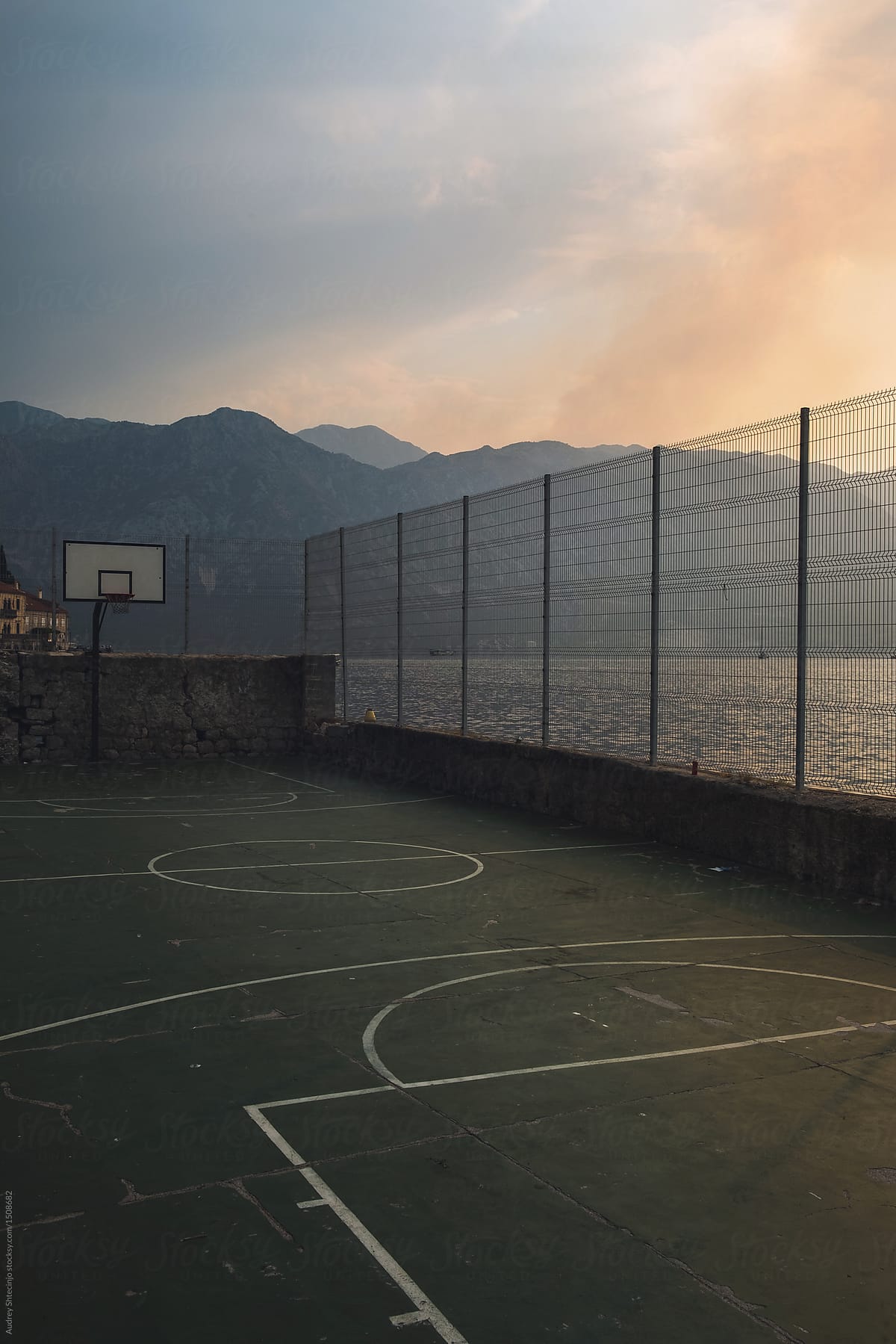 Half basketball courts with view of majestic mountain and overcast